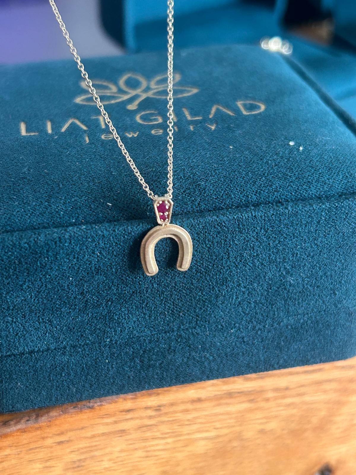 תליון פרסה מזהב עם אבני חן